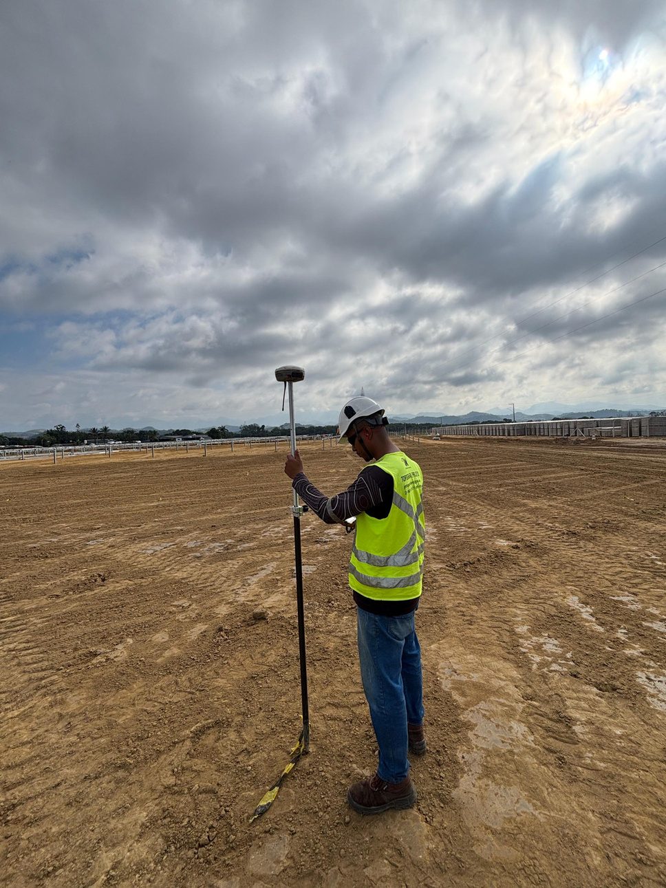 Topógrafo com GNSS RTK demarcando área rural