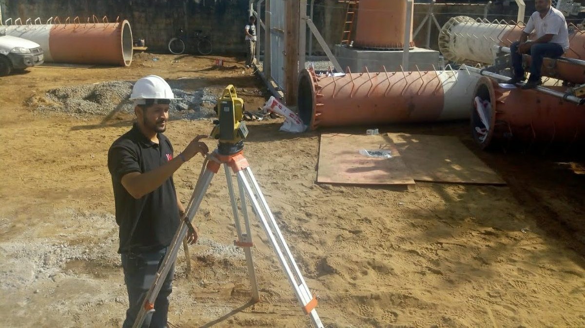 Engenheiros da JM Topografia e Engenharia em obra, operando estação total